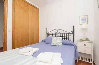 a bedroom with a blue bed with towels on it at apartamento playa la barrosa in Chiclana de la Frontera