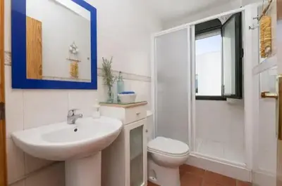 a white bathroom with a sink and a toilet at apartamento playa la barrosa in Chiclana de la Frontera