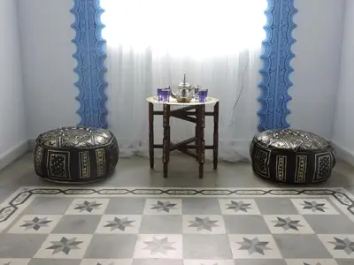 a room with two ottoman stools and a table at Hotel La Fonda del Califa in Arcos de la Frontera