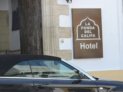 a car parked in front of a hotel sign at Hotel La Fonda del Califa in Arcos de la Frontera