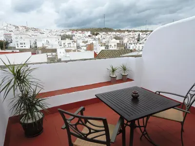 a table and chairs on a balcony with a view of a city at Hotel La Fonda del Califa in Arcos de la Frontera