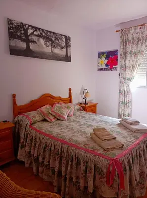 a bedroom with a large bed with a red blanket at Casa con Piscina Privada y Barbacoa en Chiclana Capacidad hasta 10 personas in Chiclana de la Frontera