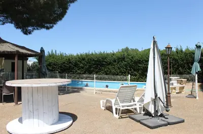 a table and a chair and an umbrella next to a pool at Casa con Piscina Privada y Barbacoa en Chiclana Capacidad hasta 10 personas in Chiclana de la Frontera
