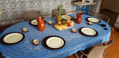 a blue table with white plates and fruit on it at Casa con Piscina Privada y Barbacoa en Chiclana Capacidad hasta 10 personas in Chiclana de la Frontera