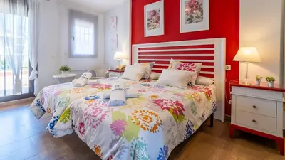 a bedroom with a large bed with a red wall at Villa Italia Conil de la Frontera by Ruralidays in Conil de la Frontera