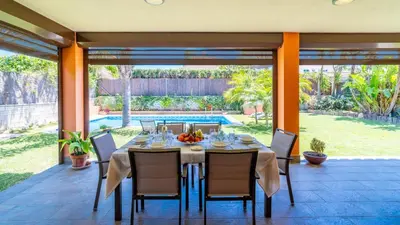 a dining room with a table and chairs and a pool at Villa Italia Conil de la Frontera by Ruralidays in Conil de la Frontera