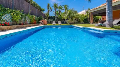 a swimming pool with blue water in a backyard at Villa Italia Conil de la Frontera by Ruralidays in Conil de la Frontera