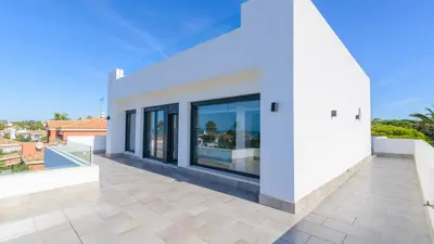 a white house with a large balcony with glass doors at Villa Mónaco Conil de la Frontera by Ruralidays in Conil de la Frontera