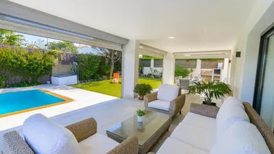 a living room with a swimming pool and a patio at Villa Mónaco Conil de la Frontera by Ruralidays in Conil de la Frontera
