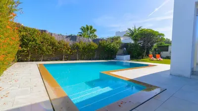 a swimming pool with blue water in a backyard at Villa Mónaco Conil de la Frontera by Ruralidays in Conil de la Frontera