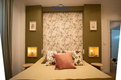 a bedroom with a large bed with a floral headboard at Casa Alcoba de la luz in Sanlúcar de Barrameda