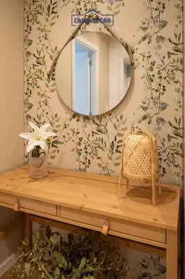 a bathroom with a mirror and a table with a wicker chair at Casa Alcoba de la luz in Sanlúcar de Barrameda