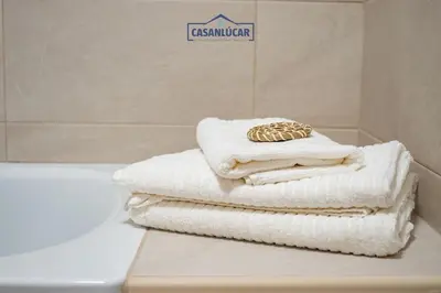 a pile of towels sitting on a counter in a bathroom at Casa Alcoba de la luz in Sanlúcar de Barrameda