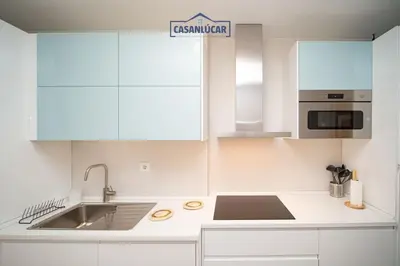 a white kitchen with white cabinets and a sink at Casa Alcoba de la luz in Sanlúcar de Barrameda