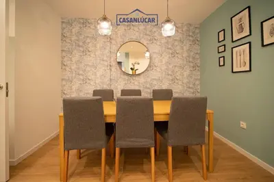 a dining room with a table with chairs and a mirror at Casa Alcoba de la luz in Sanlúcar de Barrameda