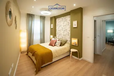 a bedroom with a bed with a sign on the wall at Casa Alcoba de la luz in Sanlúcar de Barrameda