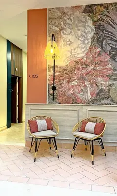 two chairs in a lobby with a painting on the wall at Soho Boutique Cádiz in Cádiz