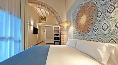 a bedroom with a bed and a wall with a mirror at Soho Boutique Cádiz in Cádiz