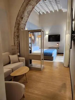 a hotel room with a bed and a couch and a room at Soho Boutique Cádiz in Cádiz