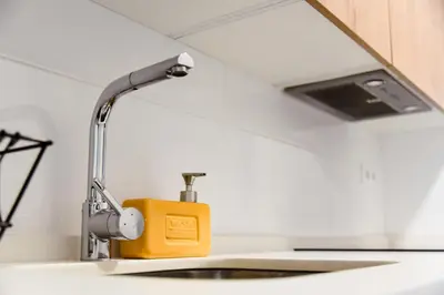 a kitchen sink with a faucet and a yellow box at Apartamento Residencial Punta Candor in Rota