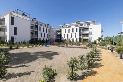 a playground in front of two white buildings at Apartamento Residencial Punta Candor in Rota