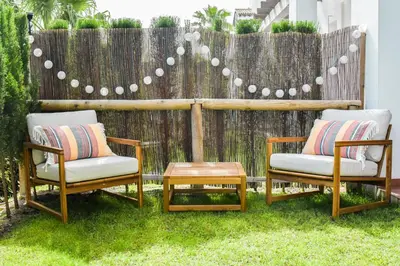 two chairs and a table in front of a fence at Apartamento Residencial Punta Candor in Rota