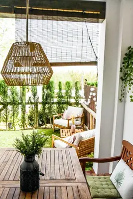 a porch with a wooden table and aandelier at Apartamento Residencial Punta Candor in Rota