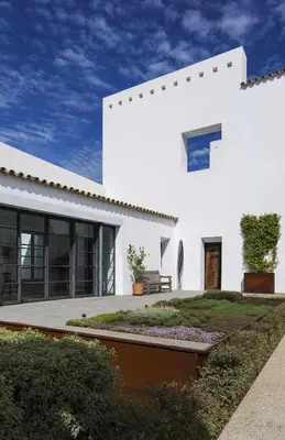 a white house with a courtyard in front of it at Cortijo exclusivo rodeado de un olivar centenario in Arcos de la Frontera