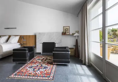 a bedroom with a bed and a television and a rug at Cortijo exclusivo rodeado de un olivar centenario in Arcos de la Frontera