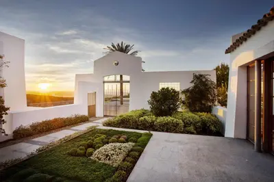 a white house with a garden in front of it at Cortijo exclusivo rodeado de un olivar centenario in Arcos de la Frontera