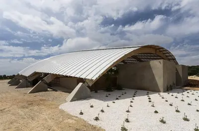 a building with a curved roof in the desert at Cortijo exclusivo rodeado de un olivar centenario in Arcos de la Frontera