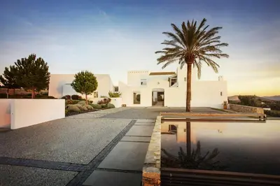 a villa with a palm tree in the middle of a driveway at Cortijo exclusivo rodeado de un olivar centenario in Arcos de la Frontera