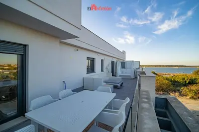 a table and chairs on a balcony with a view of the ocean at El Anfitrión - Barra del río in Sanlúcar de Barrameda