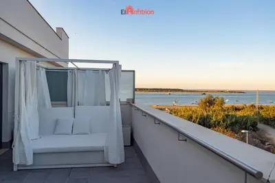 a balcony with a chair and a view of the water at El Anfitrión - Barra del río in Sanlúcar de Barrameda