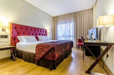 a hotel room with a large bed and a desk at Exe Guadalete in Jerez de la Frontera