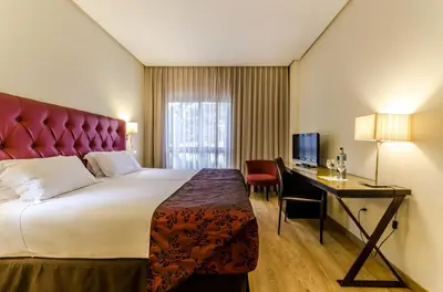 a hotel room with a large bed and a desk at Exe Guadalete in Jerez de la Frontera