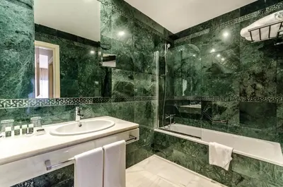a green bathroom with a sink and a shower at Exe Guadalete in Jerez de la Frontera
