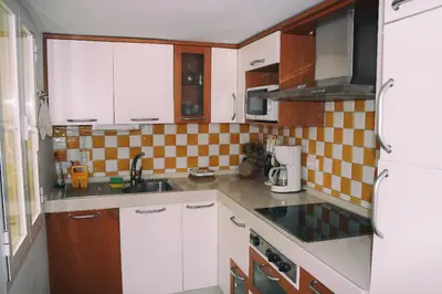 a small kitchen with white cabinets and a sink at PENTHOUSE WITH LARGE TERRACE IN CENTER OF CÁDIZ in Cádiz