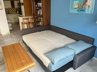 a bed sitting in a room next to a table at PENTHOUSE WITH LARGE TERRACE IN CENTER OF CÁDIZ in Cádiz
