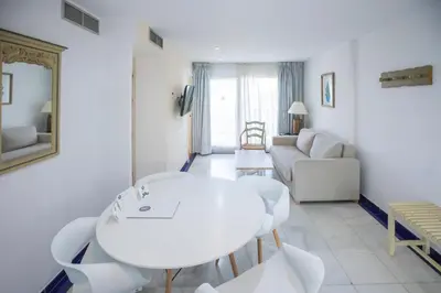 a white living room with a white table and a couch at Apartamentos Soho Boutique Vistahermosa in El Puerto de Santa María