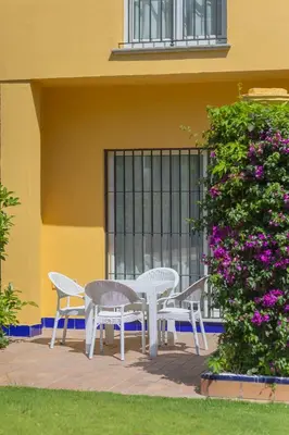 a table and chairs on a patio in front of a building at Apartamentos Soho Boutique Vistahermosa in El Puerto de Santa María
