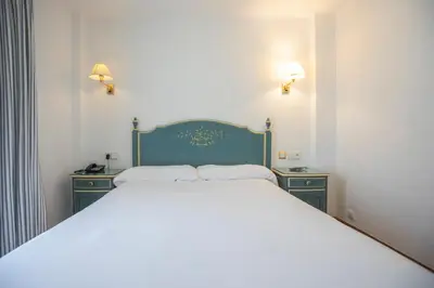 a bedroom with a large bed with two night stands at Apartamentos Soho Boutique Vistahermosa in El Puerto de Santa María