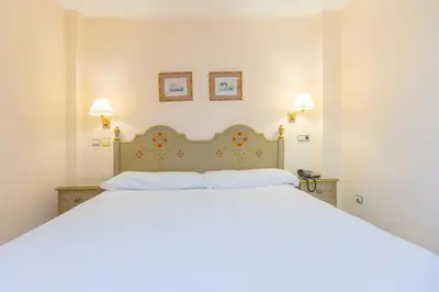 a bedroom with a large white bed with two pillows at Apartamentos Soho Boutique Vistahermosa in El Puerto de Santa María