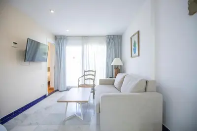 a living room with a white couch and a table at Apartamentos Soho Boutique Vistahermosa in El Puerto de Santa María