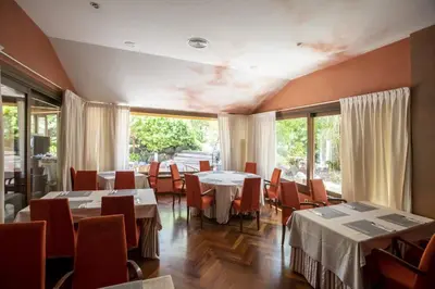 a dining room with tables and chairs and windows at Soho Boutique Vistahermosa in El Puerto de Santa María