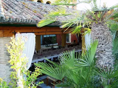 an outdoor patio with palm trees and a building at Soho Boutique Vistahermosa in El Puerto de Santa María