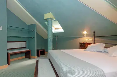 a bedroom with a white bed and a piano at Soho Boutique Jerez in Jerez de la Frontera