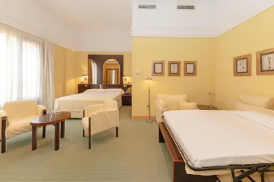a hotel room with two beds and a table and chairs at Soho Boutique Jerez in Jerez de la Frontera