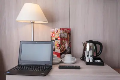 a laptop computer sitting on top of a table with a lamp at Hotel Salymar in San Fernando