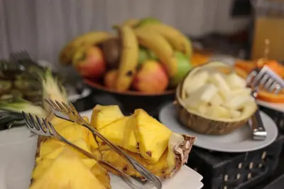 a table with plates of food with forks and fruit at Hotel Salymar in San Fernando
